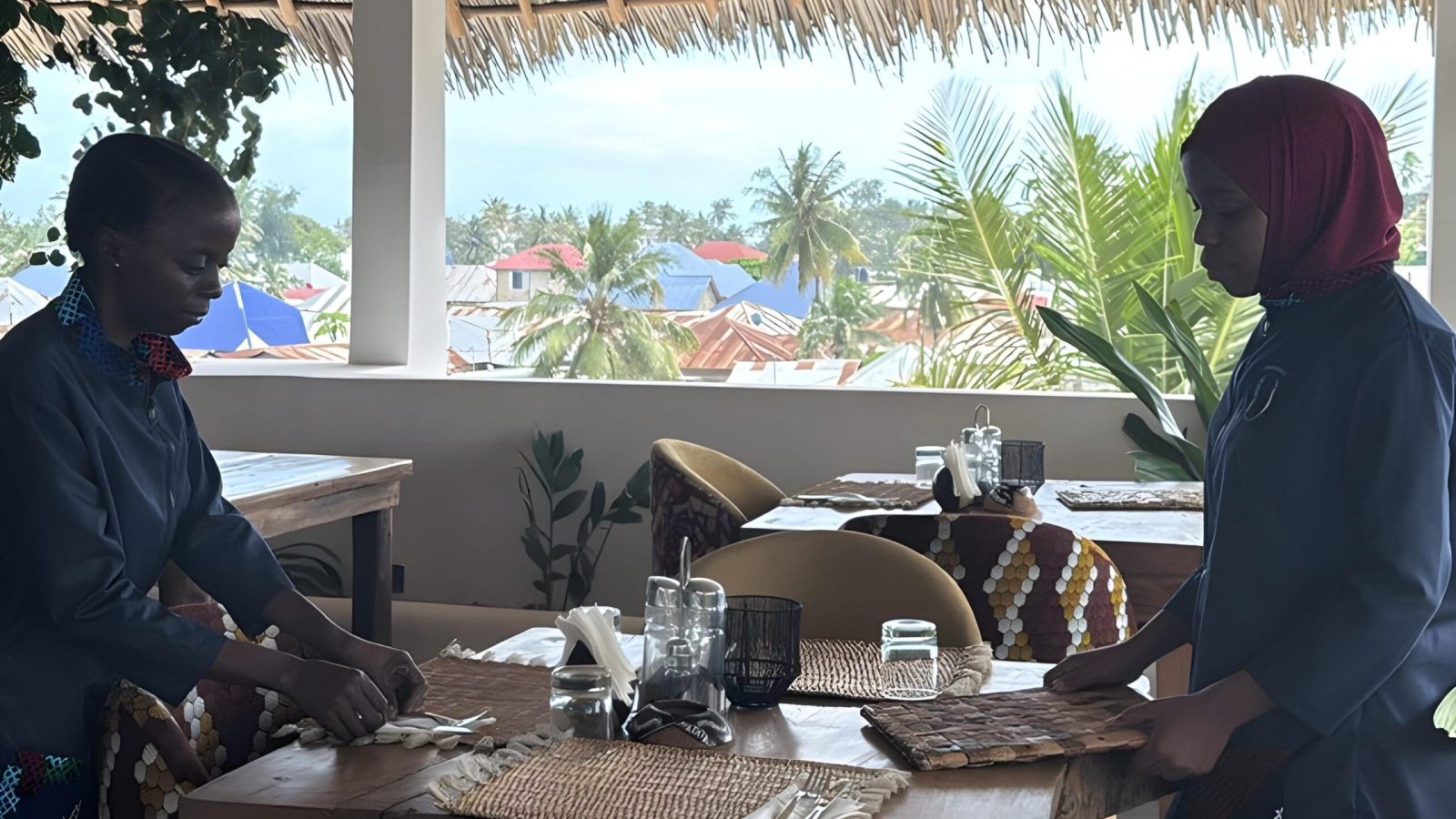 Shaded outdoor seating area with palm trees at ÔTALIA Hotel Restaurant