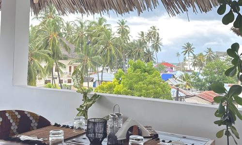 Ô TALIA ZANZIBAR Restaurant9 Shaded outdoor seating area with palm trees at ÔTALIA Hotel Restaurant